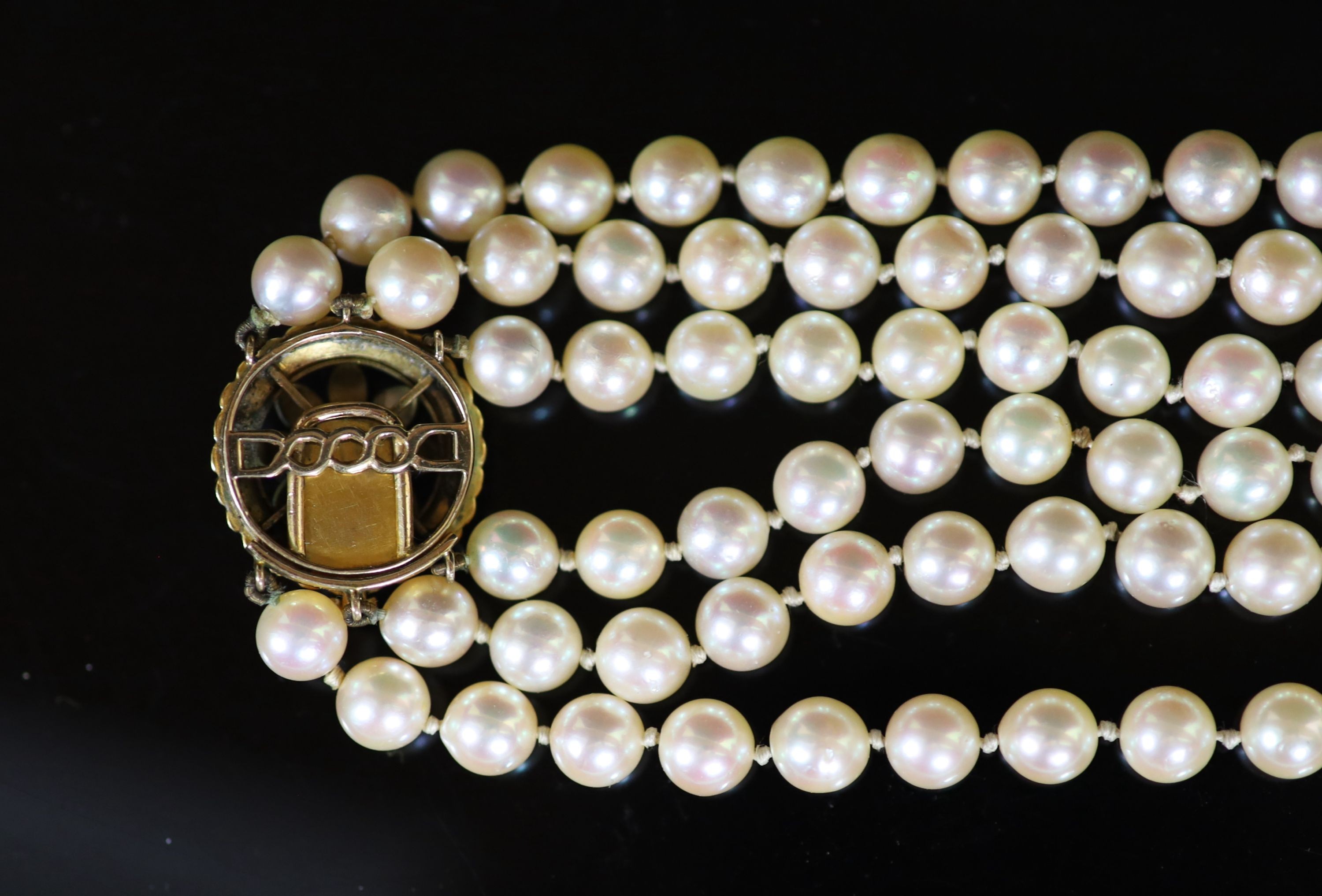 A mid 20th century triple strand cultured pearl choker necklace, with gold, seed pearl and enamel set circular clasp